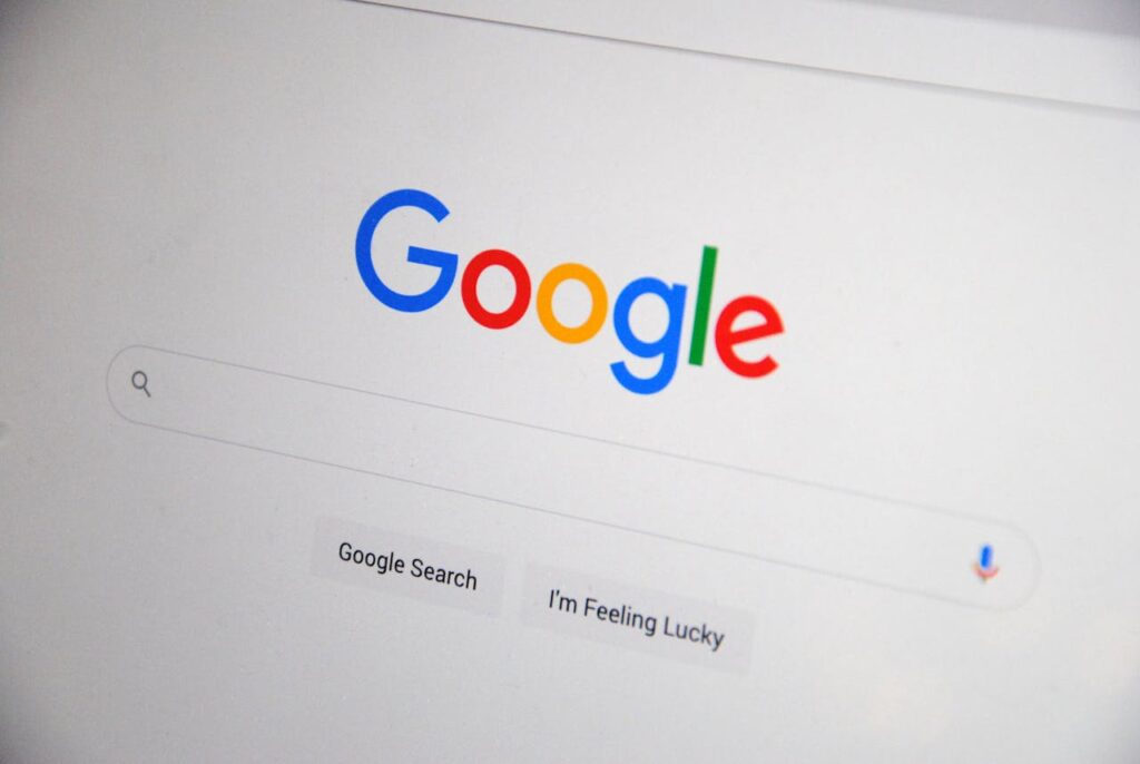 pexels-photo-13628541 Close-up of the Google homepage on a screen showing search options.